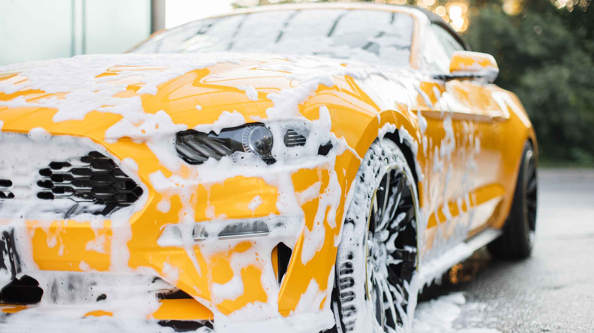 yellow ford mustang with soapy exterior